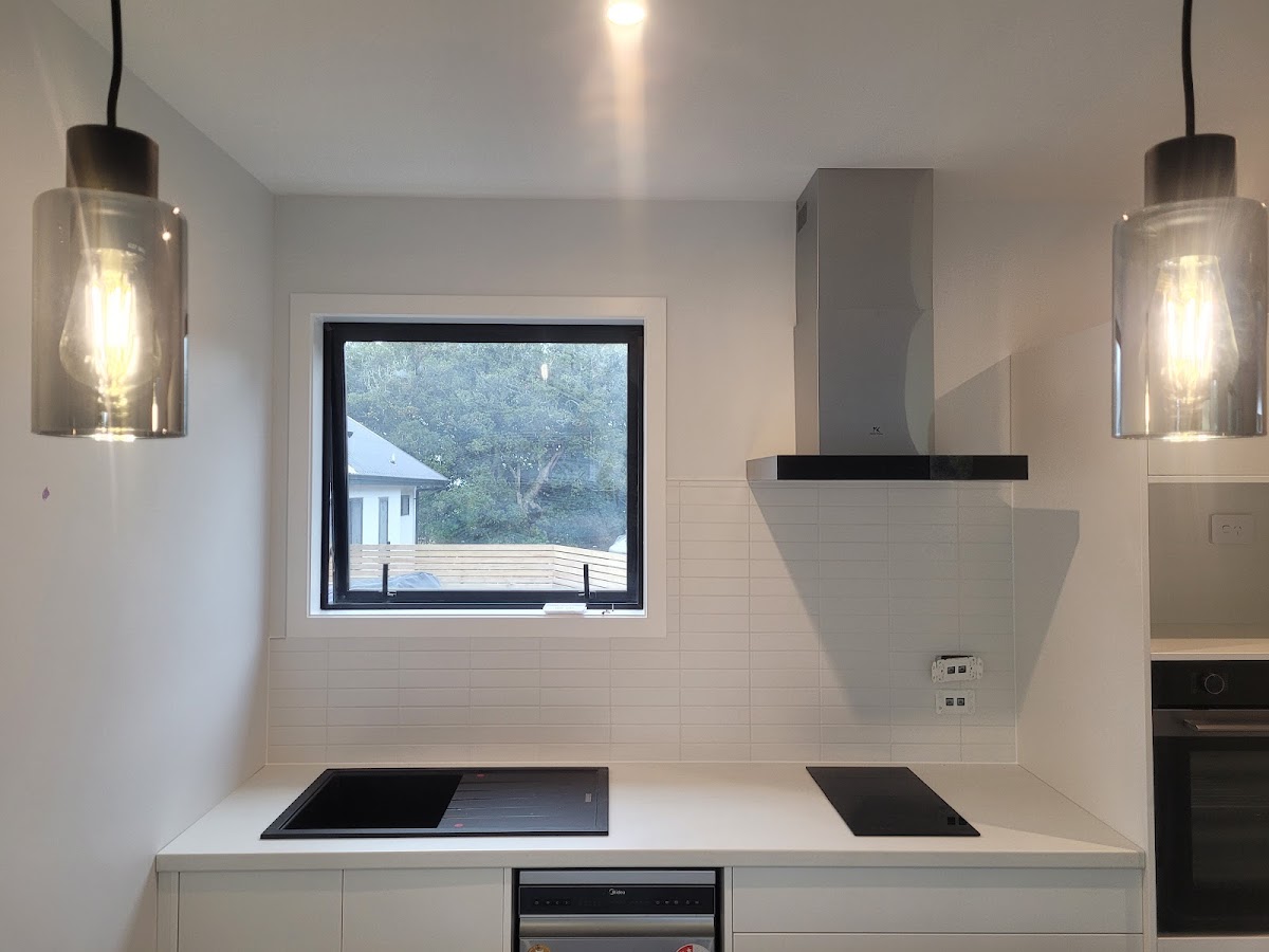 Linear white tile splashback in a minimalist kitchen